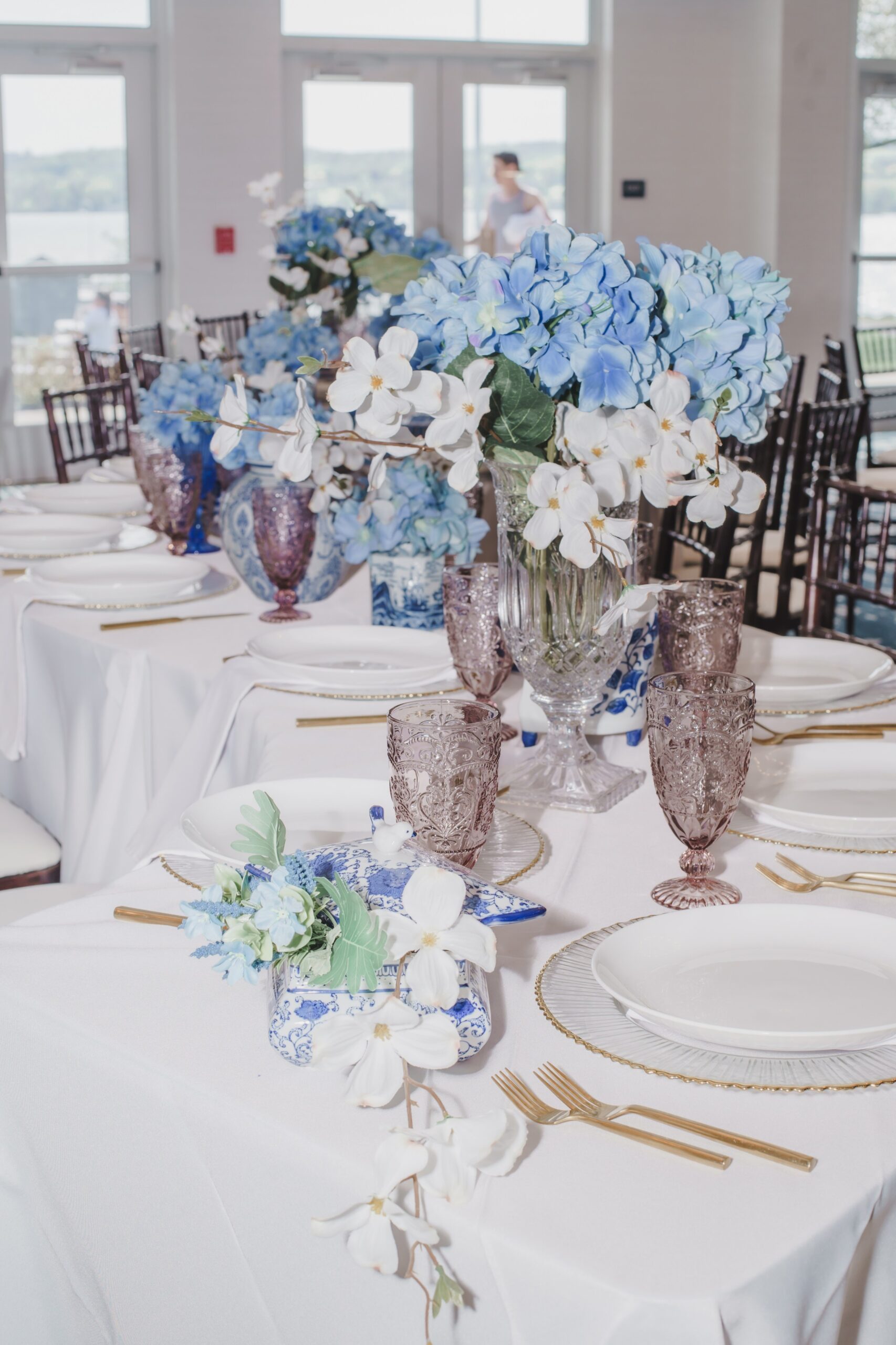 Blue colored social event set in ballroom blue and purple accent flowers